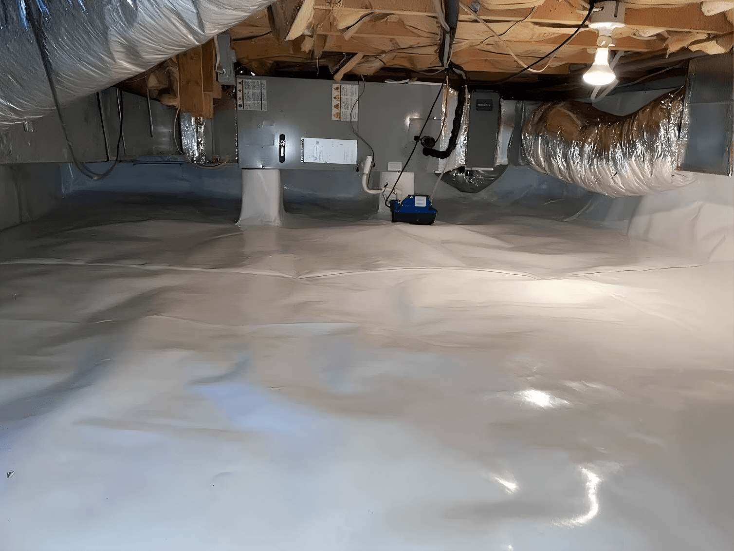 Encapsulated crawl space with a white vapor barrier covering the floor and foundation walls, featuring HVAC equipment, ductwork, a dehumidifier, and exposed floor joists to create a clean, moisture-controlled environment.