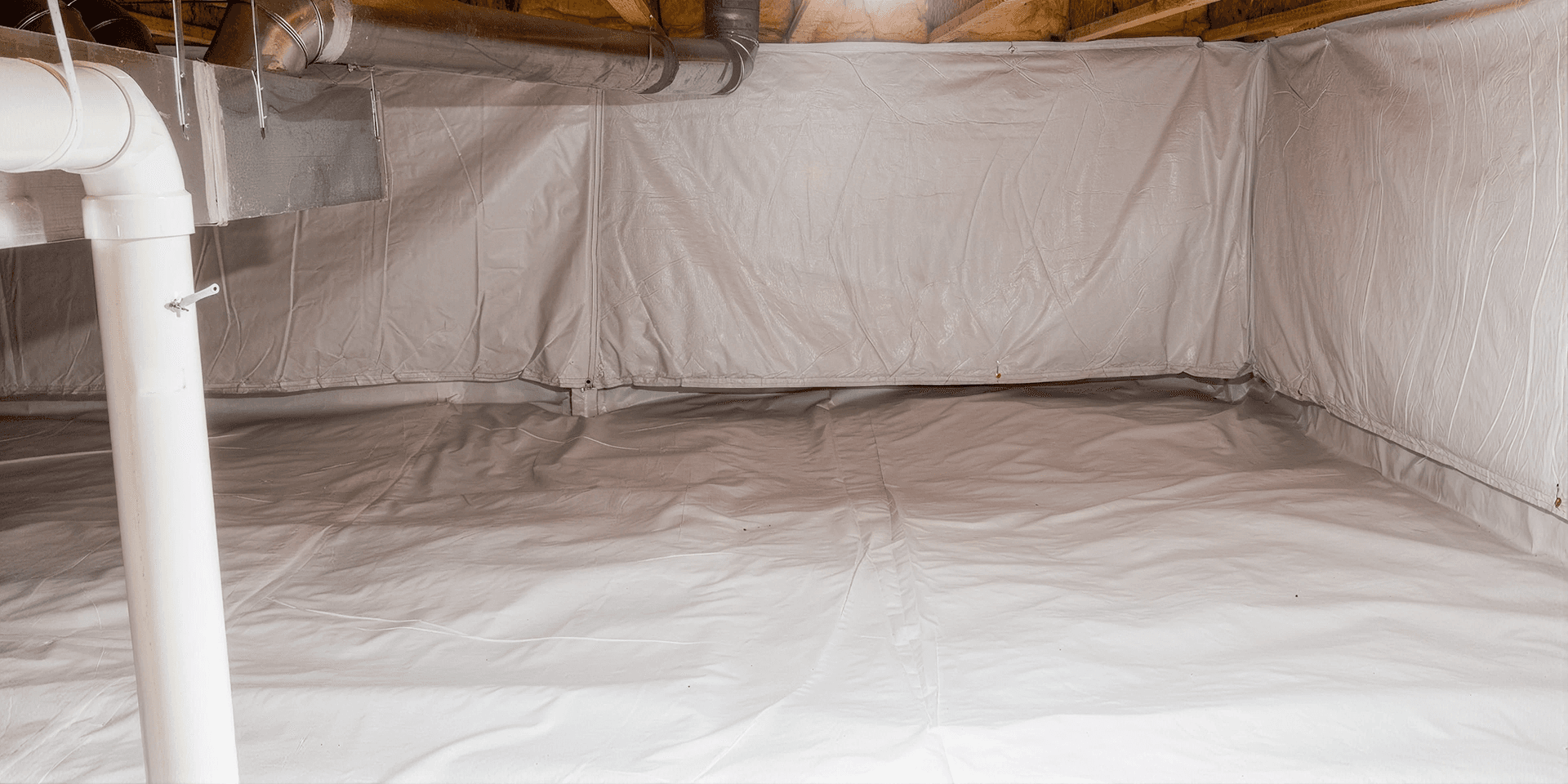 Encapsulated crawl space with a durable white vapor barrier covering the floor and foundation walls, exposed HVAC ductwork and plumbing overhead, and a clean, sealed environment designed to reduce moisture, improve air quality, and protect the home's foundation.
