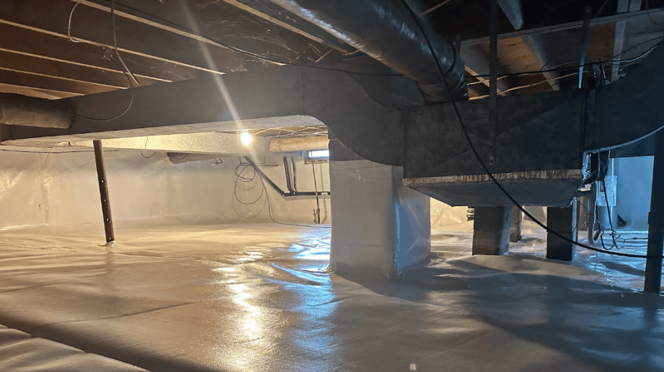 Industrial unfinished basement with reflective concrete flooring, exposed ducts, pipes, beams, and warm work lights creating a stark atmosphere.