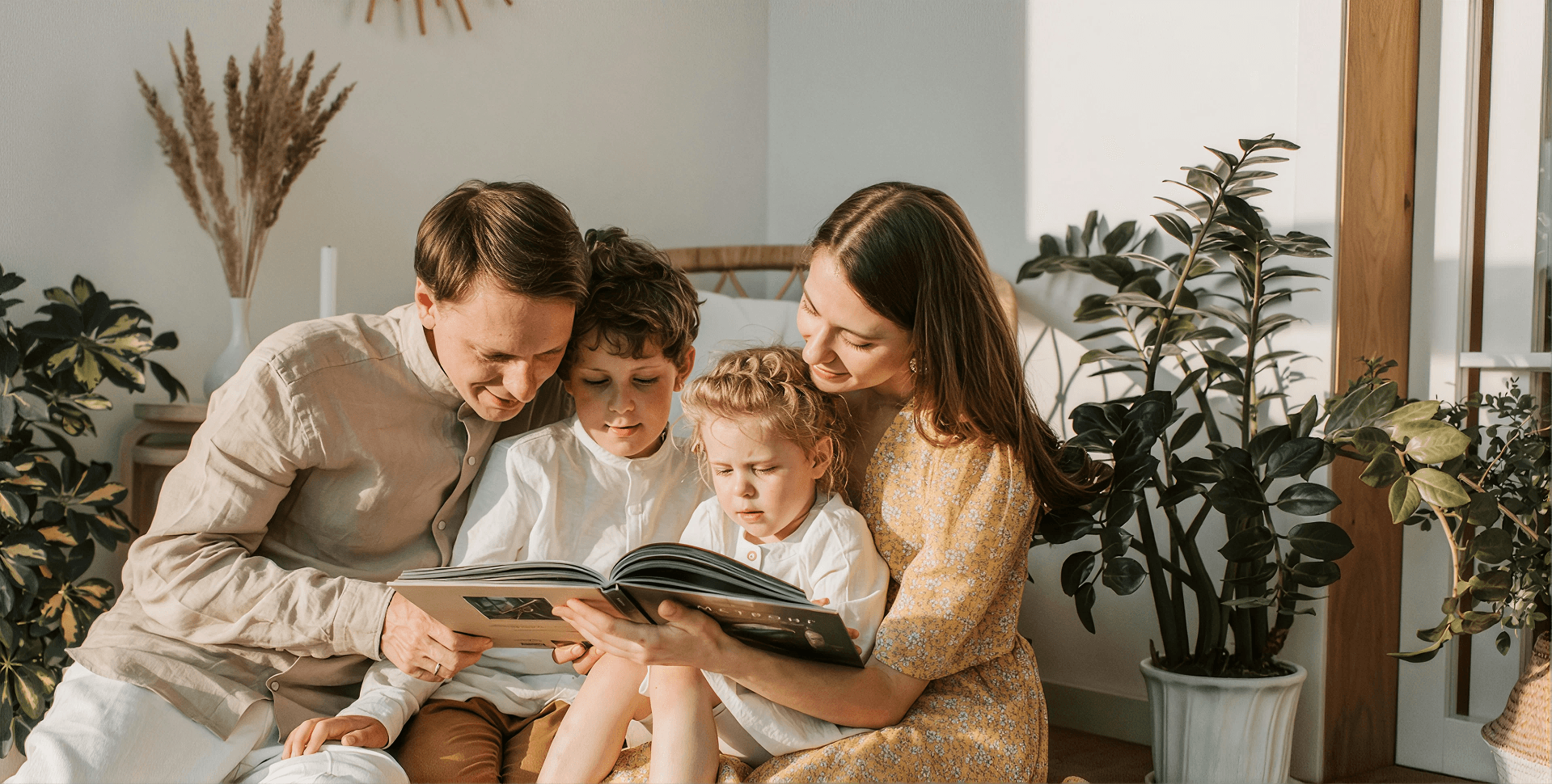 Family gathered together in a bright, comfortable home, reading a book and enjoying quality time in a clean, healthy living environment made possible by a safe, well-maintained home.